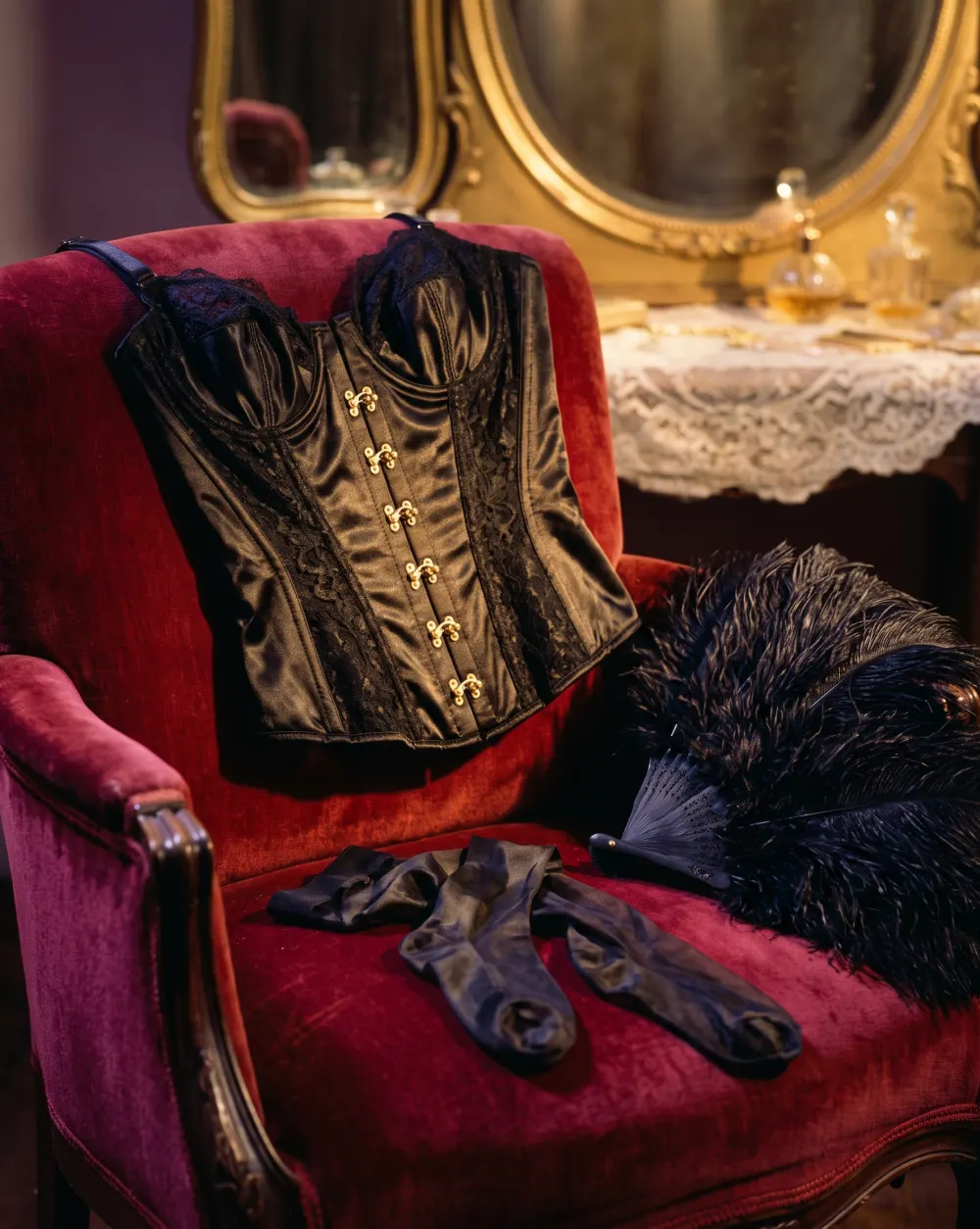 Corsetto in pizzo nero drappeggiato su una sedia, luce calda